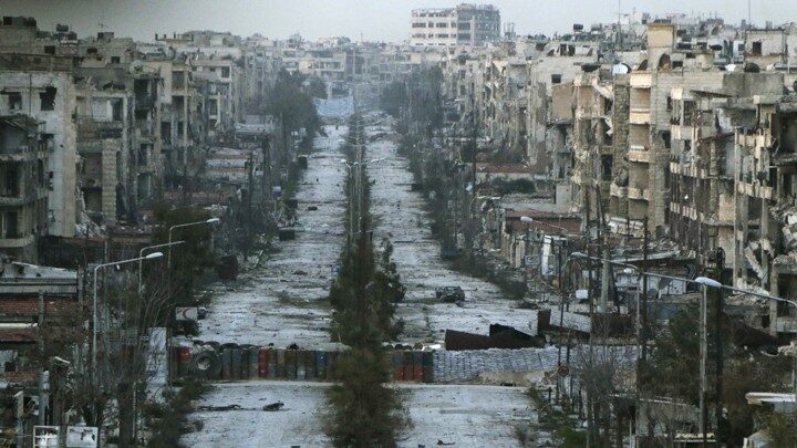 a-general-view-shows-a-damaged-street-with-sandbags-used-as-barriers-in-aleppos-saif-al-dawla-district