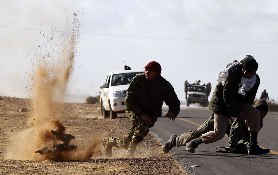 rebel-fighters-jump-away-from-shrapnel-during-heavy-shelling-by-forces-loyal-to-libyan-leader-muammar-gaddafi-near-bin-jawad